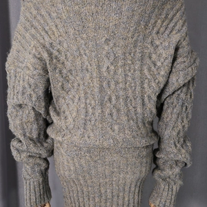 Detail shot of cable-knit patterns and ribbed hem on dark grey wool blend dress