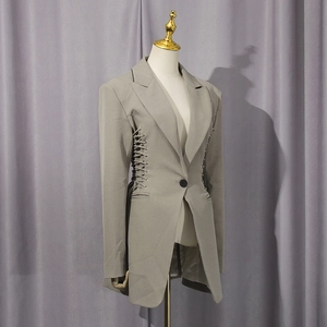 Detail of waist drawstring tie design on a slim fit dark grey long sleeve blazer