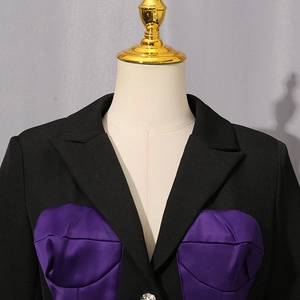 Detail of black blazer featuring a contrasting purple satin bustier panel and classic lapel