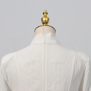 Detail of elegant white dress showing back invisible zipper and textured fabric surface