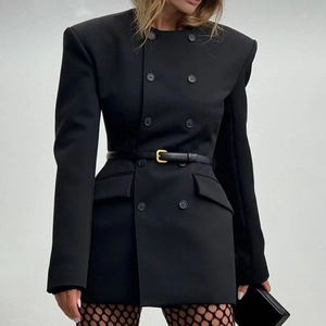 Detail of a black double-breasted blazer dress featuring a metal buckle belt and structured fit