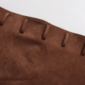 Detail of waist stitching and belt loops on a brown suede skirt with high waist design