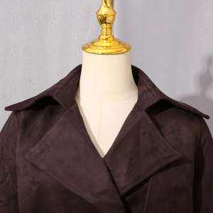 Détail d'un col en daim marron foncé sur une veste courte vintage cintrée pour femme