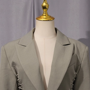 Detail of khaki blazer featuring side drawstring lace-up waist with cutout design