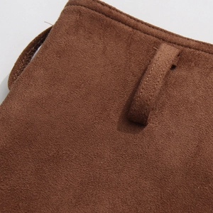 Detailed macro view of dark brown suede fabric with precise stitching and a functional strap loop