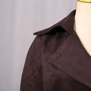 Détail du large revers et de la texture en daim doux sur une veste de rue marron foncé