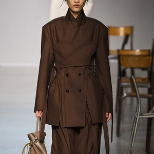 Detailed view of dark brown deconstructed blazer with layered design and waist belt