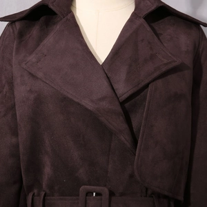 Détail de la texture en daim marron foncé et des coutures sur le trench-coat