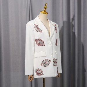 Détails des patchs à lèvres en strass rouges et argentés sur un blazer blanc cintré