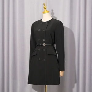 Detail of slim-fit black double-breasted dress showing metal buckle belt and flap pockets