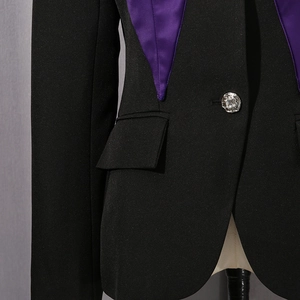 Close-up of contrast satin lapel and decorative diamond button on black blazer