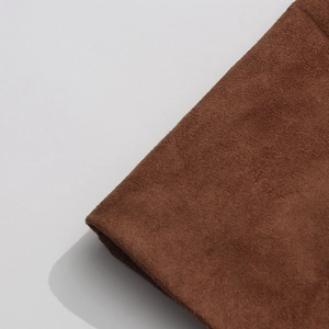 Close-up of soft dark brown faux suede fabric showing rich texture and matte finish
