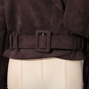 Détail d'une veste courte en similicuir marron avec large ceinture et boucle rectangulaire