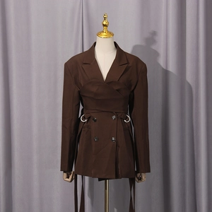 Detail of dark brown blazer with asymmetric layered waist wrap and metal buckle strap