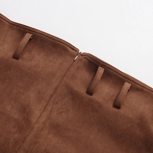 Detail of high-waisted brown suede skirt showing stitching, belt loops and hidden zipper