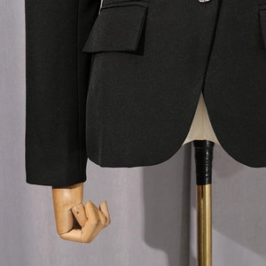Detail view of the sleek curved hem and flap pocket on a black slim fit blazer jacket