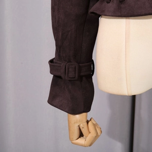 Gros plan d'une manchette de veste en daim marron foncé avec boucle carrée assortie