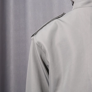 Gros plan sur l'épaule d'une veste grise avec épaulette et texture de tissu sergé