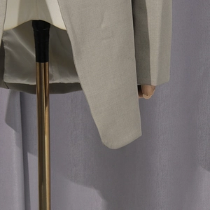Detailed close-up of gray blazer showing twill fabric texture and hem craftsmanship