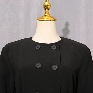 Close-up of the black double-breasted jacket with round neck and premium fabric texture
