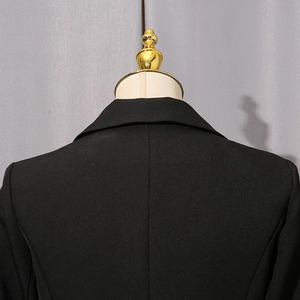 Detail view of the tailored back seams and structured collar on a black blazer jacket