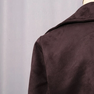 Détail du col en daim synthétique marron foncé et des coutures d'épaule de la veste