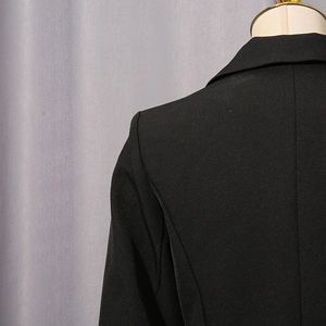 Detail view of the tailored back and shoulder seams of a slim-fit black blazer jacket