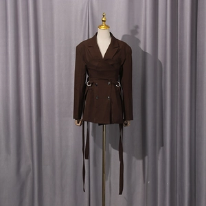 Detail of dark brown blazer featuring a metal ring buckle and adjustable long waist tie