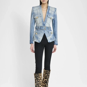 Detail of light blue washed denim blazer featuring padded shoulders and gold buttons