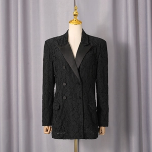 Detail of black lace blazer showing floral patterns and elegant satin peaked lapels