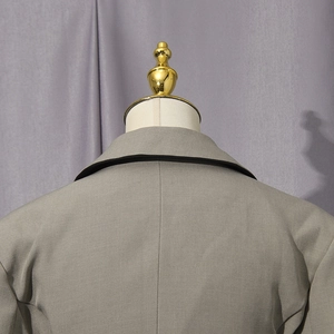 Detail of grey blazer neckline with black piped trim and high-quality tailoring craftsmanship