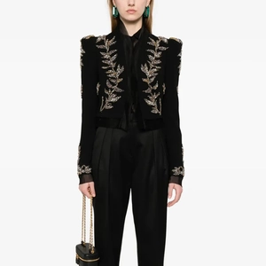 Detailed close-up of luxury black blazer featuring ornate gold wheat embroidery and sequins