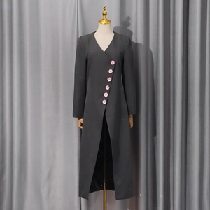 Detail of dark grey blazer featuring decorative pink flower buttons and a high front slit