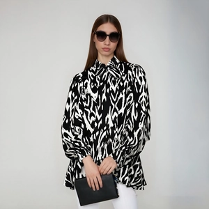 Detail of pussy-bow neck and abstract black and white print on loose lantern sleeve shirt