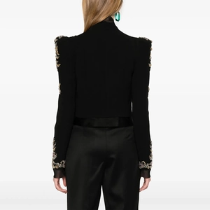 Detail of black fitted cropped blazer showing gold sequin embroidery on shoulders and sleeves