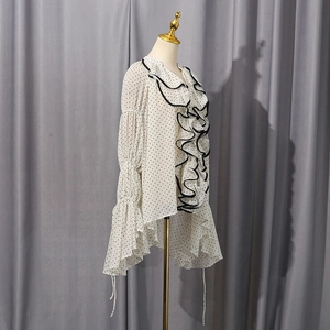 Close-up of elegant ruffled front and black polka dot pattern on chiffon blouse
