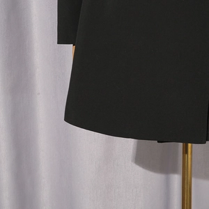 Detail shot of black slim-fit blazer showing high-density woven fabric and neat hem stitching