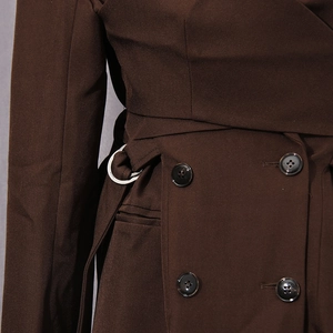 Close-up of deep brown blazer featuring classic double-breasted buttons and belt buckle