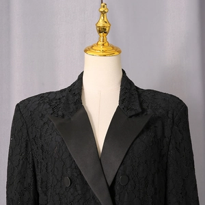 Detail of black lace blazer showing satin peak lapels and intricate floral lace texture