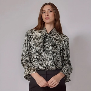 Detailed close-up of the tie-neck bow and geometric maze print on this long sleeve blouse