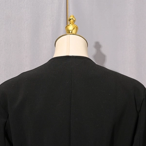 Detail of the back neckline and fine woven texture on the black tailored blazer