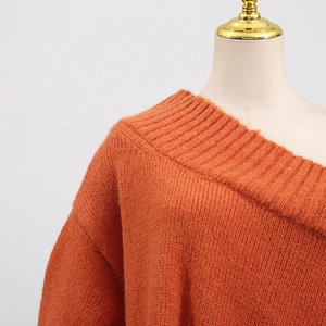 Detail of burnt orange chunky knit sweater showing ribbed neckline and drop shoulder texture