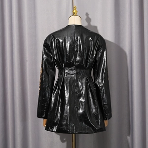 Détails des plis à la taille et texture croco brillante sur le blazer noir chic