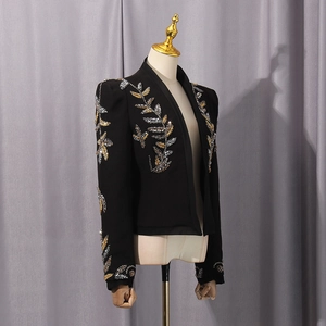Detail of shimmering gold and silver sequin leaf embroidery on a black blazer sleeve