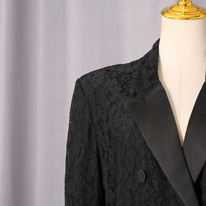 Detail of floral lace texture and black satin peak lapels on a fitted blazer
