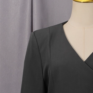 Detailed close-up of dark grey V-neck collar and tailored shoulder of casual blazer