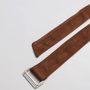 Close-up of a brown suede belt with polished silver double D-ring metal buckles
