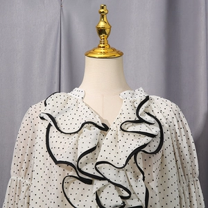 Detail of ruffle trim with black piping on long sleeve beige polka dot chiffon blouse