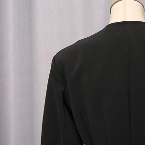 Detail of professional black blazer shoulder tailoring and premium matte fabric texture