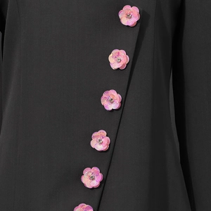 Detailed macro view of pink sequin petal buttons with rhinestones on black blazer sleeve
